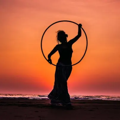 Woman holding hoop in sunset glow — symbolizing inner peace, balance, and spiritual reconnection