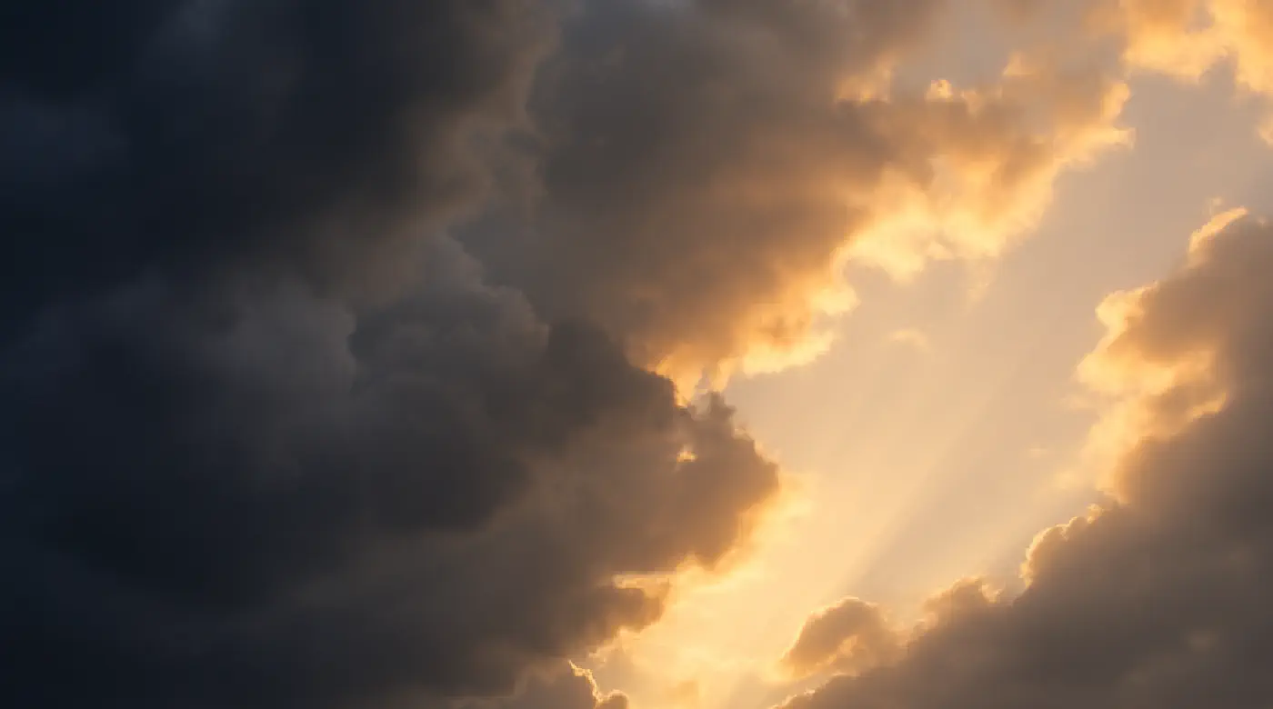 Dark storm clouds parting to reveal sunlight — symbolizing emotional clarity and healing