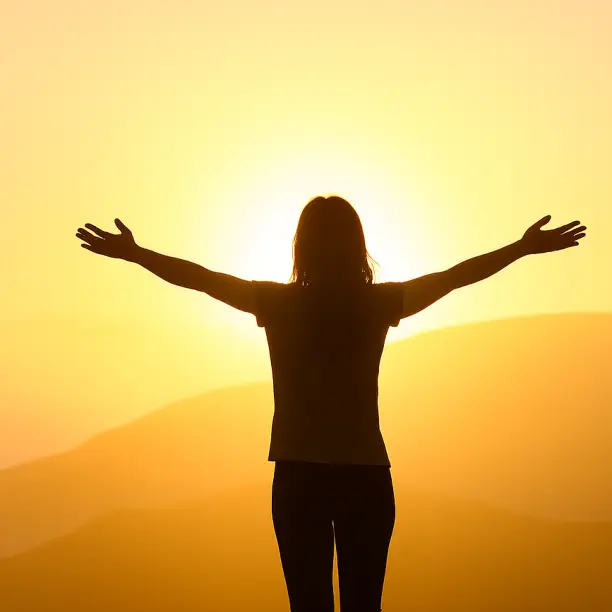 Silhouette of a woman with open arms at sunrise symbolizing emotional freedom and healing through Releasing Therapy in Chiang Mai